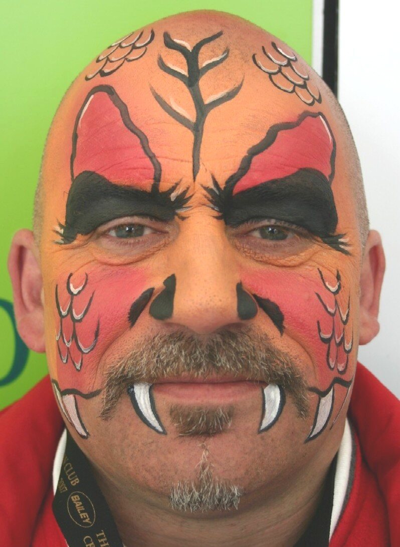 Dramatic red dragon adult face-painting design by Hazel Wood