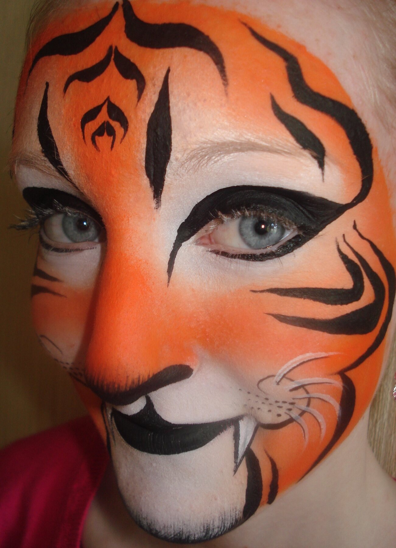 Orange tiger adult face-painting design by Hazel Wood