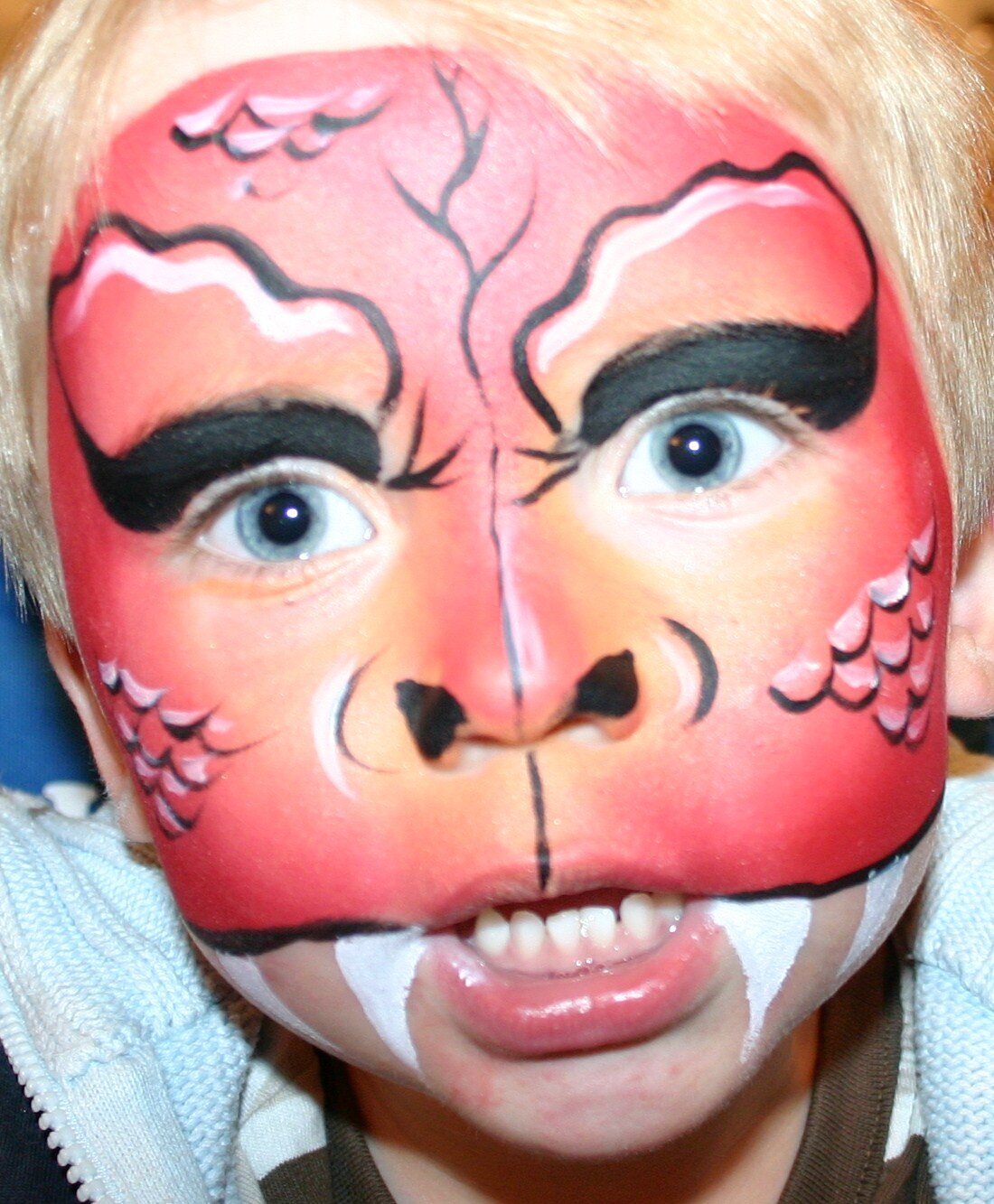 Red dragon face-painting design by Hazel Wood