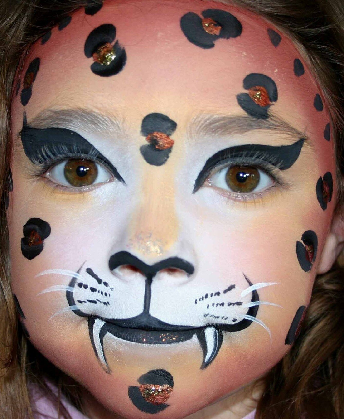 Spotted big-cat face-painting design by Hazel Wood