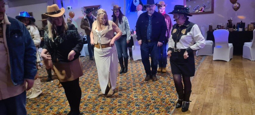 Guests taking part in line dancing together