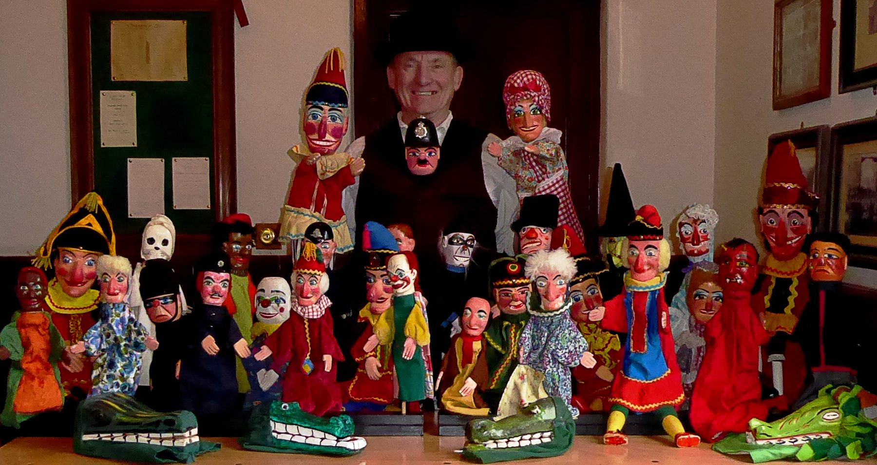Professor Ron surrounded by a large display of Punch and Judy puppets at Beamish in 2019