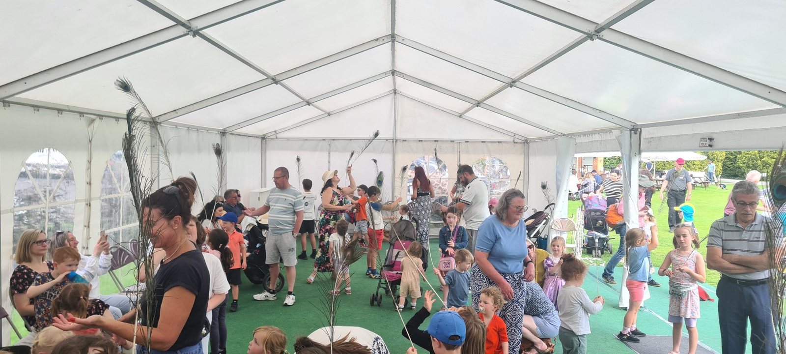 Children and adults trying feather balancing during a circus skills workshop at Burnby Hall Gardens