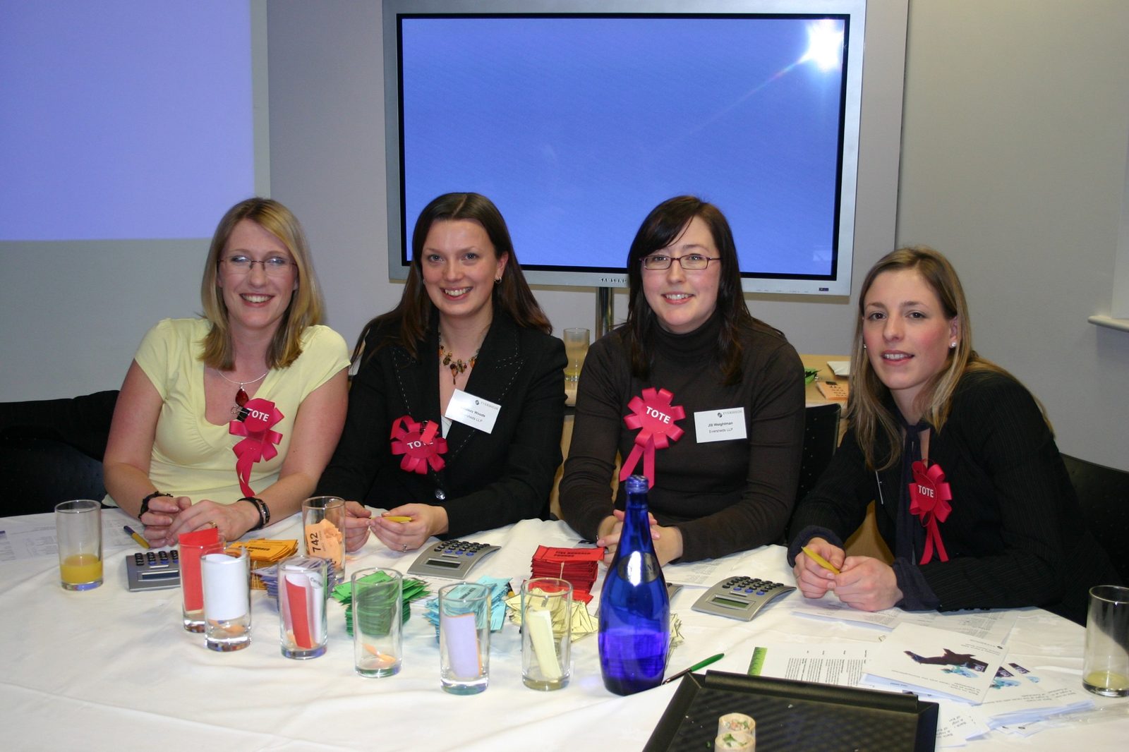 Four Eversheds staff wearing red Tote rosettes