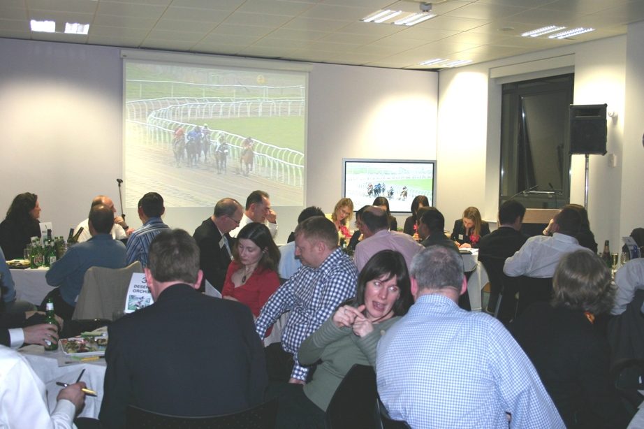A horse race being shown to guests during the Eversheds Race Night