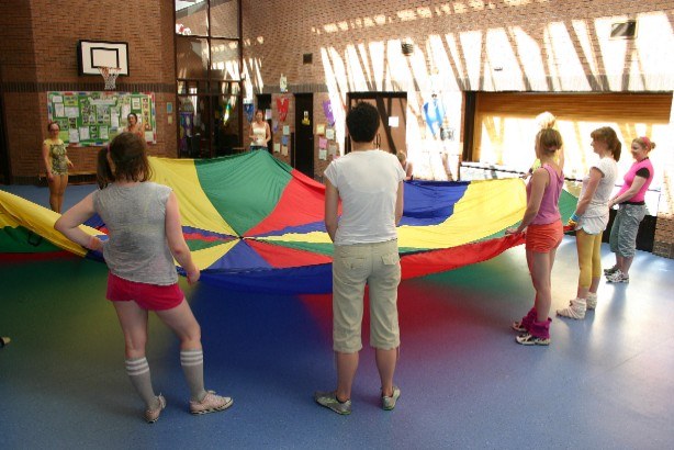 Adults taking part in colourful parachute games at a hen party